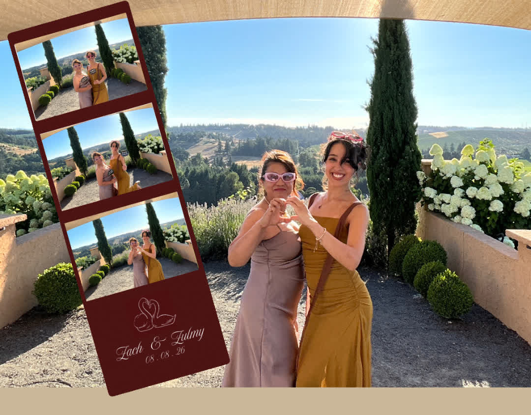 Wedding guests posing with a photo strip at an Oregon vineyard photo booth